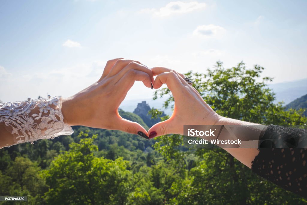 Closeup shot of a heart sign mad by women hands on mountains background A closeup shot of a heart sign mad by women hands on mountains background Adult Stock Photo