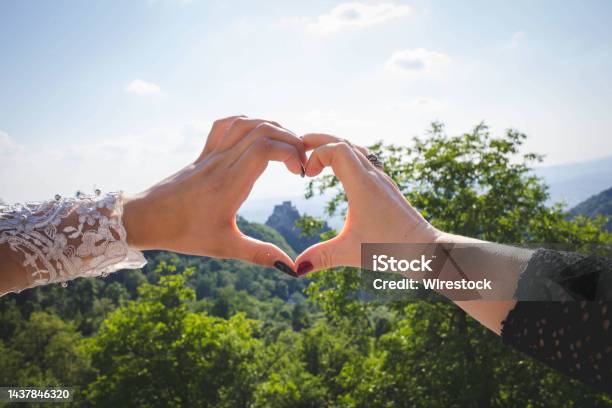 Closeup Shot Of A Heart Sign Mad By Women Hands On Mountains Background Stock Photo - Download Image Now