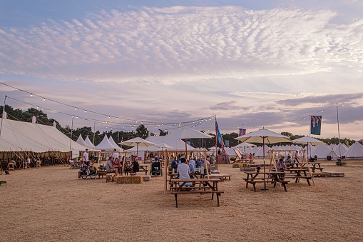 Southwold, United Kingdom – July 29, 2022: General scenes from the Latitude Music Festival, in Suffolk. The open-air sitting area under the scenic cloudy sky.