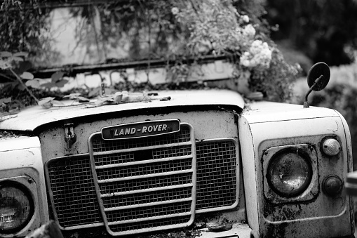 Manchester, United Kingdom – July 25, 2022: Manchester UK 25 July 2022 black and white image of front of old Land rover 4 x 4 off road vehicle showing grill logo and headlights
