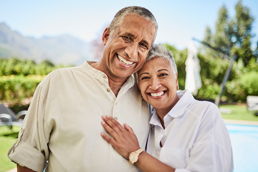Happy, smile and portrait of senior couple standing in the backyard of their family home. Happiness, excited and elderly man and woman from Puerto Rico in nature by the outdoor house garden together.