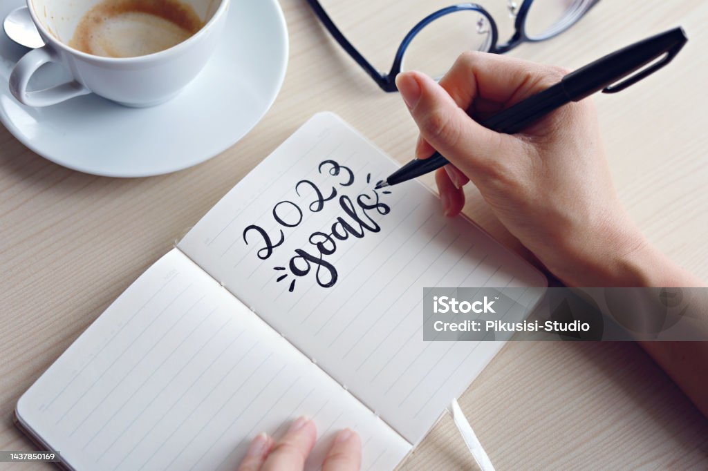 Businesswomen writing 2023 goals on notebook for new year resolution plan. 2023, new year resolution and action plan concept. New Year Resolution Stock Photo