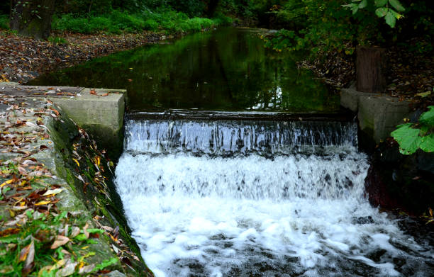 vista de um açude com falta de água para esportes aquáticos. a seca hidrológica acabou com a navegabilidade e rafting ou açude é uma barreira para remadores de peixes e jangadas - miniature weir - fotografias e filmes do acervo