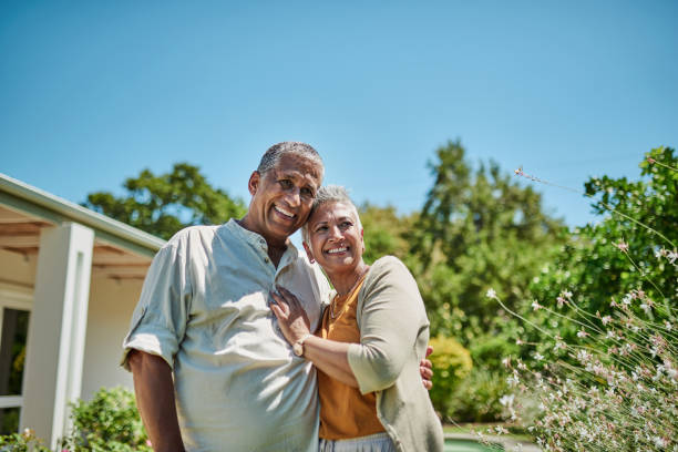 maison retraite, jardin et couple senior en portrait pour le bonheur immobilier, l’amour et la richesse avec maquette de ciel bleu. des personnes âgées heureuses s’étreignent dans leur jardin pour les vacances d’été ou de printemps - senior adult outdoors wellbeing sky photos et images de collection