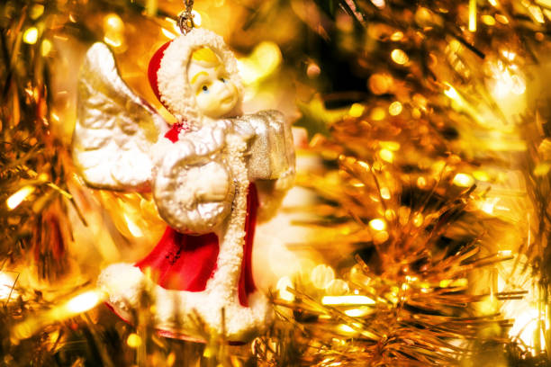 Cute toy angel hanging on decorating a Christmas tree.