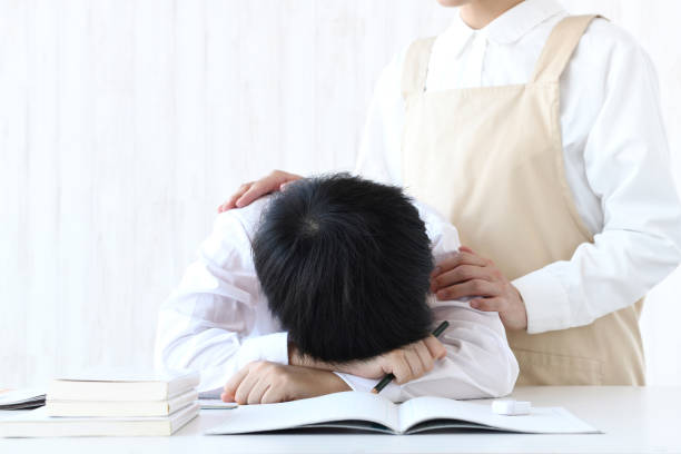 istock Boy lying face down on desk and encouraging mother 1437852463