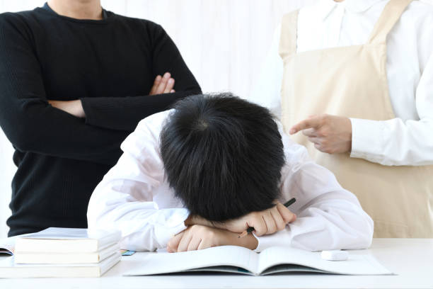 istock Boy lying face down on desk and scolding parents 1437852474