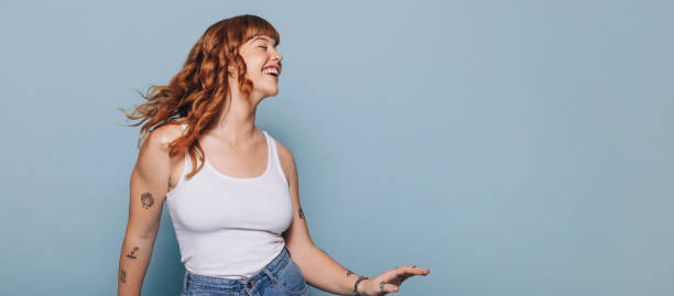donna con i capelli di zenzero che balla e si diverte in uno studio - joy cheerful happiness smiling foto e immagini stock