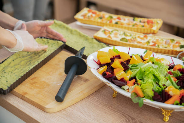 istock Cooking quiche with salmon. A woman puts spinach dough into a pie pan. 1437855032