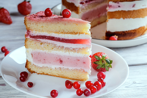 Pink and white layered cake with berries.
