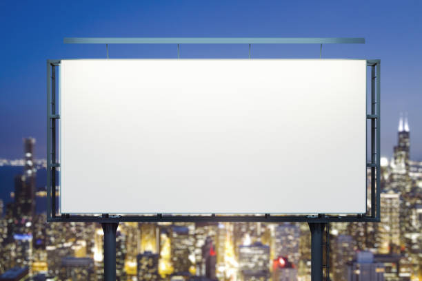 istock Blank white billboard on cityscape background at evening, front view. Mock up, advertising concept 1437857873