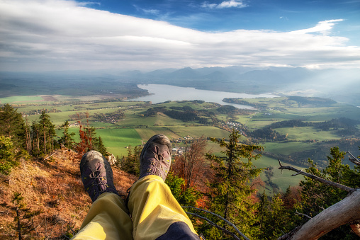 Legs of hiker with hiking boots on top of the hill with beautiful landscape under. Region Liptov in Slovakia