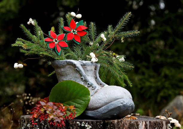 A gray shoe with fir branches and two beautiful flowers handmade of felt