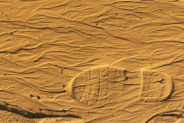 footprint of a boot tread on yellow sand. footprints in the sand