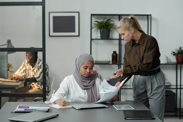istock Young female boss scolding her subordinate in hijab while showing her documents 1437862263