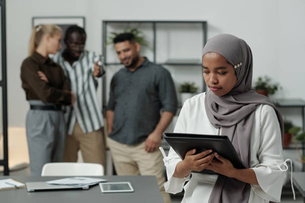 jeune femme d’affaires musulmane en hijab tenant un dossier noir avec des documents - bigotry photos et images de collection