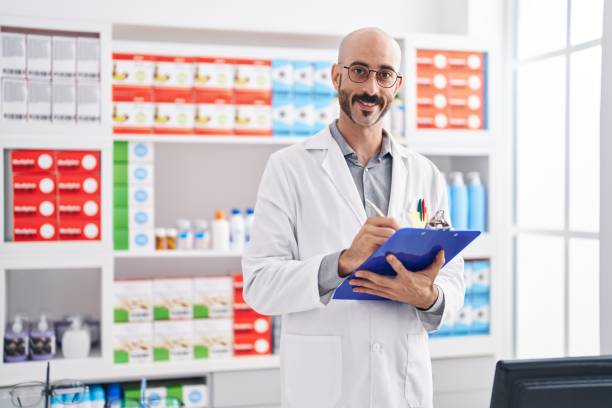istock Young hispanic man pharmacist writing on document at pharmacy 1437863124