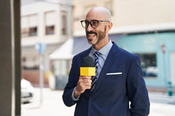 istock Young hispanic man reporter working using microphone at street 1437863141