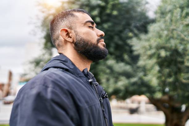 istock Young hispanic man breathing with closed eyes at park 1437864616