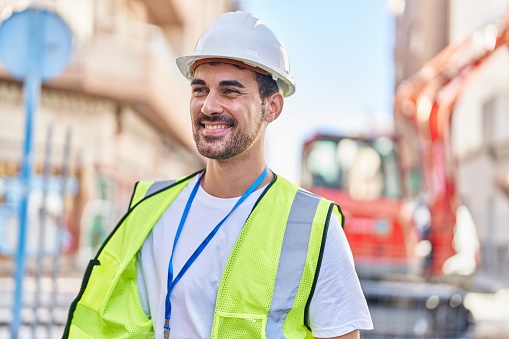 Closeup of a construction worker guiding a hose from a concrete pump and filling rebar mesh. This is fast setting concrete, takes three hours to dry.