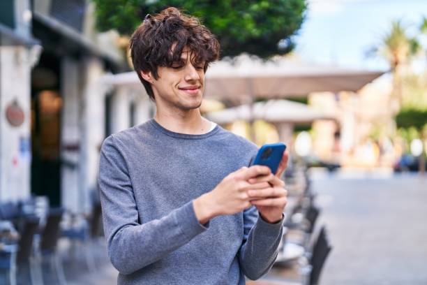 istock Young hispanic man smiling confident using smartphone at street 1437865439