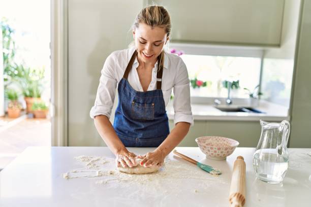 istock Young blonde woman smiling confident make pizza dough with hands at kitchen 1437866947