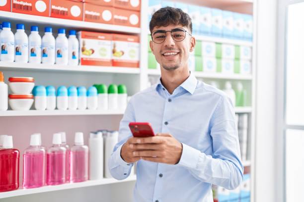 istock Young hispanic man customer smiling confident using smartphone at pharmacy 1437867015