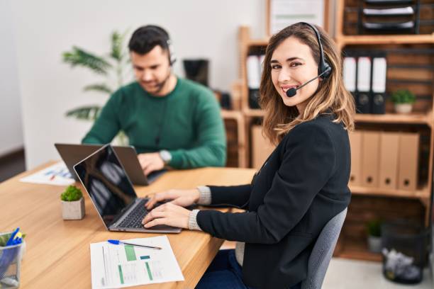 istock Man and woman call center agent using laptop working at office 1437867601