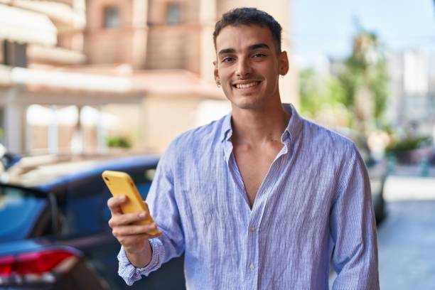 istock Young hispanic man smiling confident using smartphone at street 1437867745