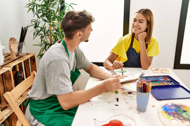 istock Young hispanic artist couple smiling happy drawing at art studio. 1437868574