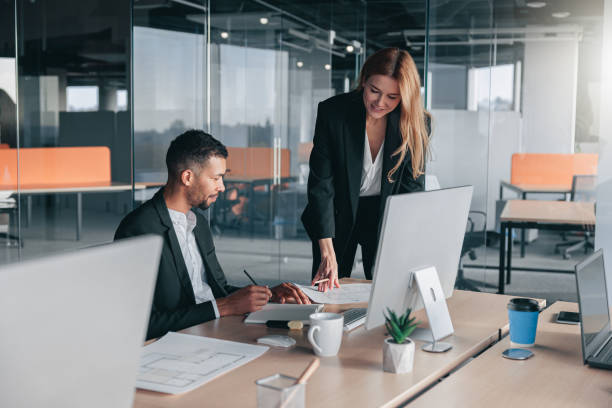 istock Two multiethnic coworkers working together analyzing the charts in office 1437869185