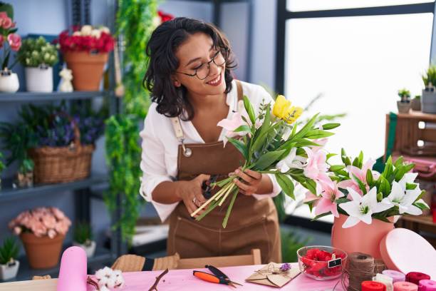 若い美しいヒスパニック系の女性花屋が花屋で花束を作る - professional occupation business one person young adult ストックフォトと画像