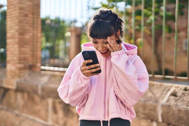 istock Young woman smiling confident using smartphone at street 1437870326