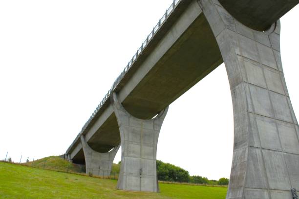 istock Low-angle view of a bridge crossing over the green fields under the white sky 1437871553