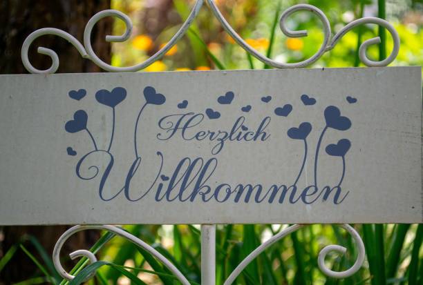 A banner fixed on a garden fence with German text on it\nTranslation-warm welcome