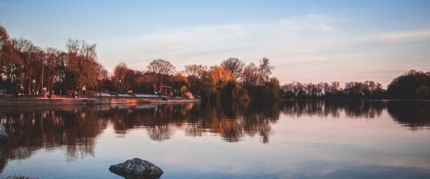 istock Panoramic view of an autumn trees with reflection in a lake under cloudy sky 1437872324