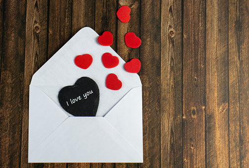 A white envelope with a black heart and the words I love you