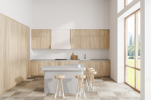 Stylish kitchen interior with bar countertop, kitchenware and panoramic window