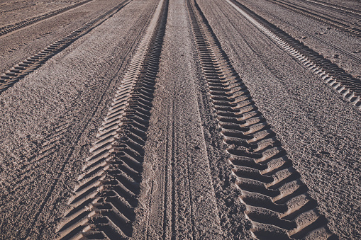 longitudinal tracks of a tractor on the sand of the beach