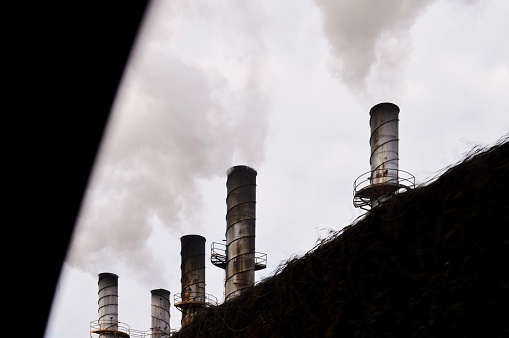 The industrial smokestacks belching smoke polluting the environment