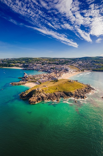 The aerial view of the rocky shore and town surrounded by sea. St Ives, Cornwall, England, UK.