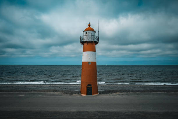 istock Tall lighthouse at the North sea under a cloudy sky 1437873541