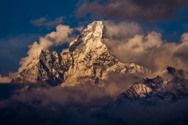 szczyt góry ama dablam w chmurach i mgle ze śniegiem odbijającym światło słoneczne - ama dablam zdjęcia i obrazy z banku zdjęć