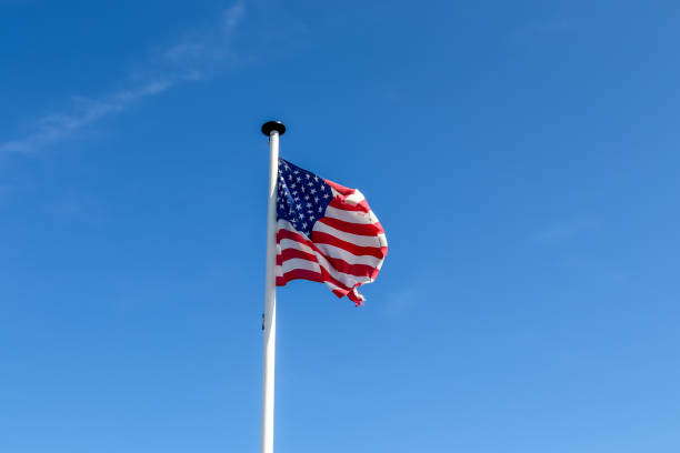 istock American flag on a pole waving in the sky 1437875994
