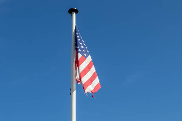 istock American flag on a pole waving in the sky 1437875998