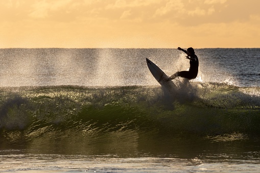 Maroochyd, Australia – July 11, 2022: The surfer riding a wave in the early morning. Maroochydore, Australia.