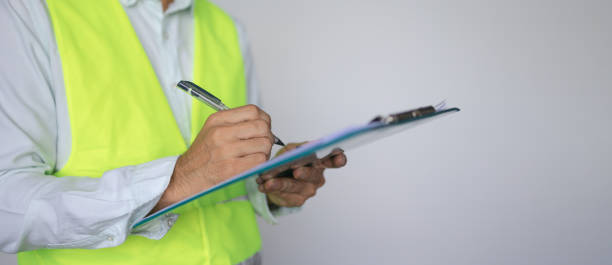 Construction worker inspector checking notes in clipboard stock photo