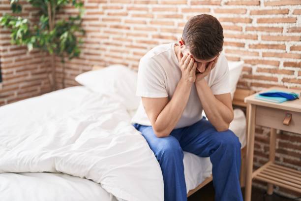 istock Young caucasian man stressed sitting on bed at bedroom 1437883492