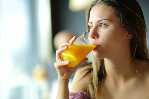 Beautiful girl drinks water with lemon