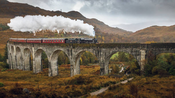 Jacobite steam train passing over Glenfinnan (Scotland) viaduct during rain fall